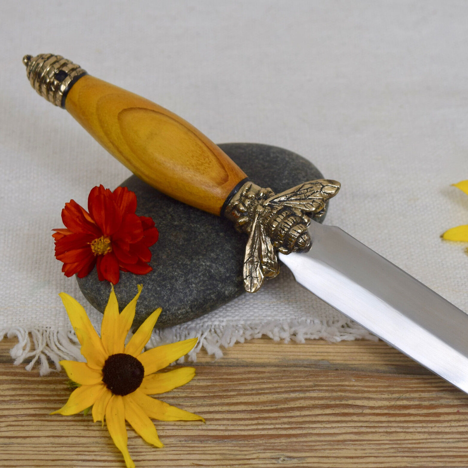 a double-edged knife with a bee hilt